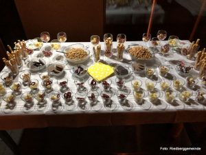 Tisch mit portionierten Leckereien in kleinen Gläsern