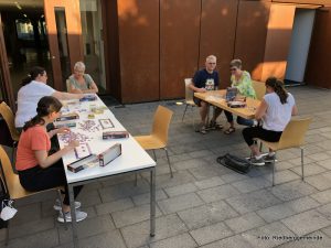 Menschen an Tischen im Freien legen Puzzles