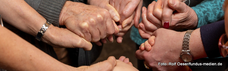 Menschen unterschiedlichen Alters halten einander an den Händen.