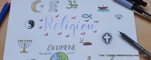 Eine Zeichnung mit Beschriftung Religion - Ökumene - dazu zahlreiche Zeichen der verschiedenen Religionen, Kreuz, Fisch, Brot, Kelch, Schriftrolle uvm.