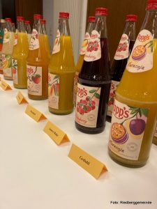 Flaschen mit verschiedenen Säften - davor stehen Schilder mit Begriffen wie Geduld, innere Ruhe, Weisheit, Gelassenheit usw. 