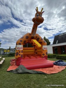 Hüpfburg in Form einer grinsenden Giraffe.