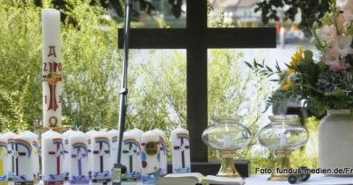 Altar im Freien mit Kreuz, Osterkerze und Taufkerzen