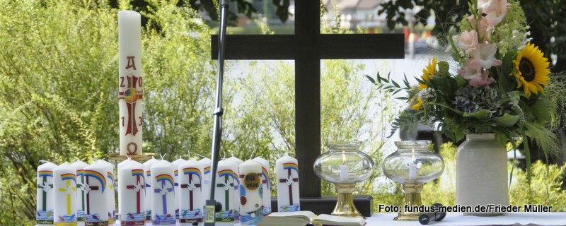 Altar im Freien mit Kreuz, Osterkerze und Taufkerzen